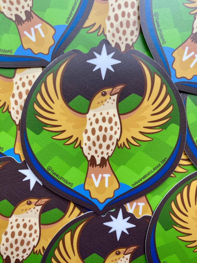 Puede incluir: Una pegatina redonda con un p&aacute;jaro estilizado con las alas extendidas. El p&aacute;jaro es principalmente amarillo y marr&oacute;n, con una estrella blanca encima. El fondo incluye elementos verdes y azules, y las letras "VT" son visibles. La pegatina tiene el texto "@TWINKLETATERS" y "DIANAMARIECLARKE.COM".