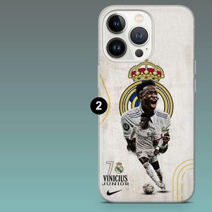 May include: A smartphone case featuring a graphic of soccer player Vinicius Junior in a white uniform. The design includes the Real Madrid crest with a crown, the number 7, the text VINICIUS JUNIOR, and a black Nike swoosh logo on a textured background.