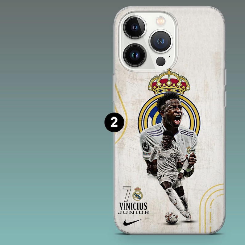 May include: A smartphone case featuring a graphic of soccer player Vinicius Junior in a white uniform. The design includes the Real Madrid crest with a crown, the number 7, the text VINICIUS JUNIOR, and a black Nike swoosh logo on a textured background.