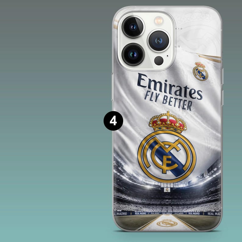 May include: A clear smartphone case featuring a graphic of a white Real Madrid jersey with the text Emirates Fly Better and the team crest. The design includes a stadium background with a crown emblem and the number 4 in a black circle.