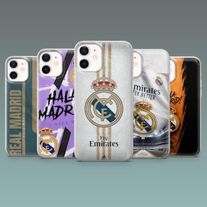 May include: A collection of five clear smartphone cases featuring various Real Madrid designs. Each case displays the club crest, team colors, and text including Real Madrid, Hala Madrid, and Fly Emirates. The cases are arranged in a row.