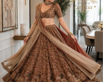 May include: A brown lehenga choli set featuring intricate embroidery, sequin embellishments, and a wide flared skirt with detailed animal motifs. The ensemble includes a matching short-sleeved blouse and a sheer, lightweight dupatta draped over the shoulder.