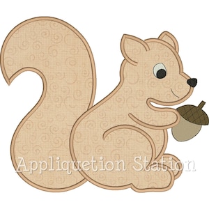 May include: A brown and white applique design of a squirrel holding an acorn. The squirrel is sitting on its haunches with its tail curled behind it. The design is perfect for embroidery or quilting projects.