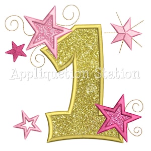 May include: Gold glitter number one with pink glitter stars and swirls. Appliquetion Station.