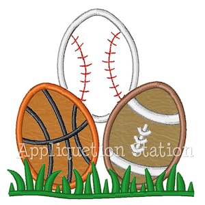 May include: Three embroidered sports balls, a baseball, basketball, and football, are arranged in a row on a green grass background. The baseball is white with red stitching, the basketball is orange with black stitching, and the football is brown with white stitching.