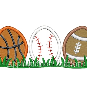 May include: Three embroidered sports balls, a basketball, baseball, and football, are arranged in a row on a green grass background.