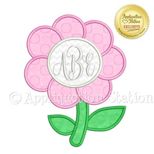 May include: A pink flower with a white circle in the center that has the letters "A B E" in a gray script font. The flower has a green stem and two leaves.