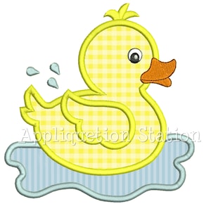 May include: A yellow rubber duck with a checkered pattern is floating in a blue and white striped pool of water. The duck has a large orange beak and black eyes.
