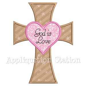 May include: A brown cross with a pink heart in the center. The heart has the words "God is Love" inside.