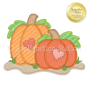 Pode incluir: Duas abóboras laranja com folhas verdes e corações costurados. As abóboras estão sentadas em um pedaço de terra marrom. O texto "Appliquetion Station" é visível na imagem.