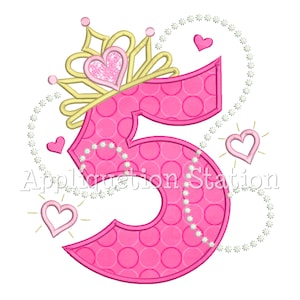 May include: A pink number 5 with a polka dot pattern, adorned with a gold crown and a heart-shaped gem. The design includes decorative hearts and a string of pearls, with the text "Application Station".