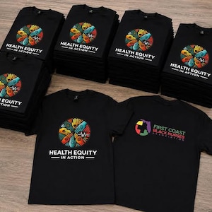 May include: A collection of black t-shirts featuring a circular graphic of multi-colored hands joined together with the text "HEALTH EQUITY IN ACTION". One shirt displays the "FIRST COAST BLACK NURSES ASSOCIATION" logo with a map of Florida.