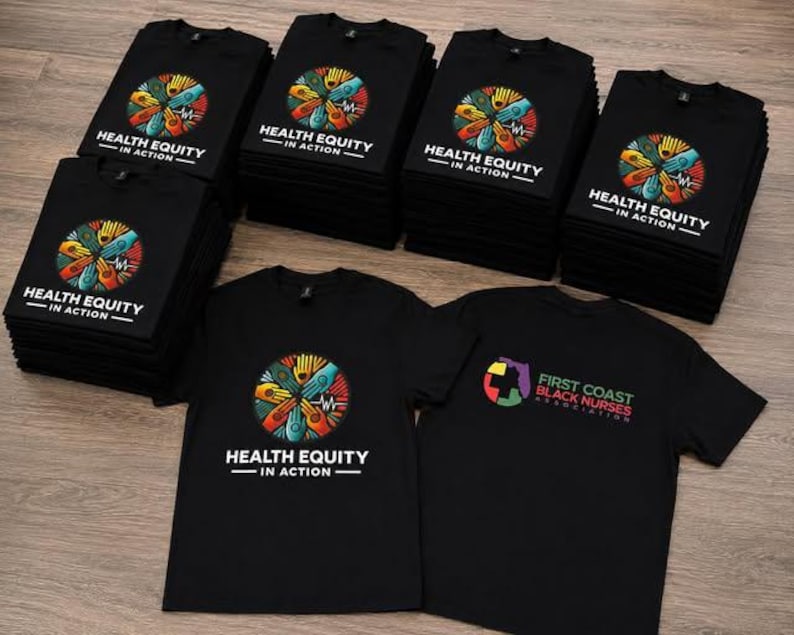 May include: A collection of black t-shirts featuring a circular graphic of multi-colored hands joined together with the text "HEALTH EQUITY IN ACTION". One shirt displays the "FIRST COAST BLACK NURSES ASSOCIATION" logo with a map of Florida.