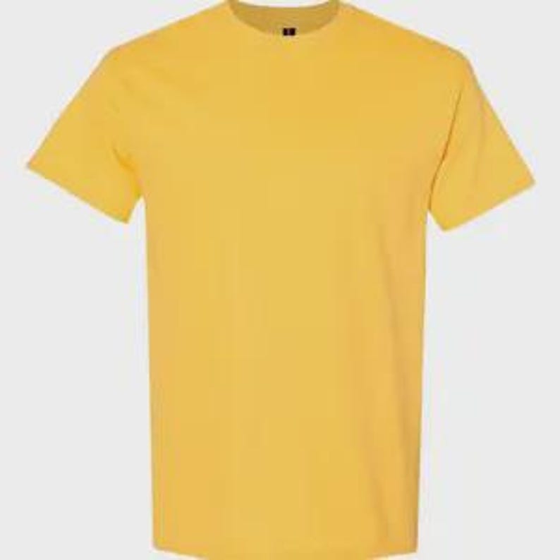 May include: A solid, vibrant yellow short-sleeved t-shirt with a classic crew neckline. The garment features a plain, unpatterned design with a standard fit, short sleeves, and a straight hemline, presented against a neutral, light gray background.
