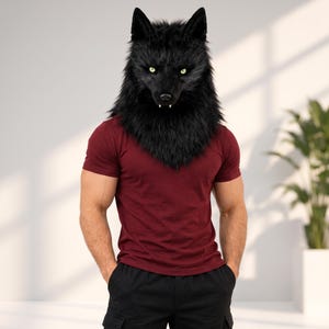 Pode incluir: Uma máscara de lobo preta realista com orelhas pontiagudas, pelo espesso e olhos amarelos brilhantes, combinada com uma t-shirt bordeaux de manga curta e calças cargo pretas. A máscara apresenta presas brancas visíveis na mandíbula.