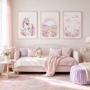 Può includere: Tre stampe da parete incorniciate con illustrazioni ad acquerello di un unicorno, un paesaggio con arcobaleno e nuvole floreali. Le stampe in cornici di legno chiaro sono esposte sopra un divano letto con cuscini pastello e un peluche.