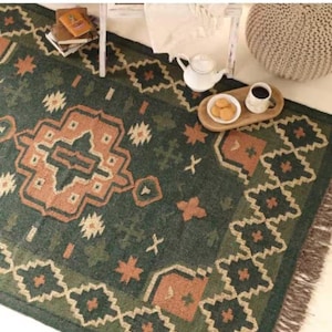 Könnte beinhalten: Ein rechteckiger Teppich mit dunkelgrünem Grund und einem sich wiederholenden geometrischen Muster in Terrakotta, Creme und Oliv. Der Teppich hat einen Fransenrand und zeigt ein symmetrisches Design aus ineinandergreifenden Rauten und Sternen.