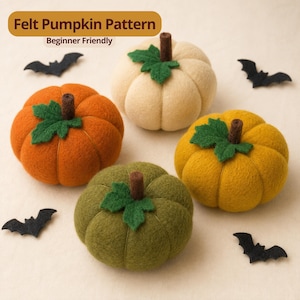 May include: Four felt pumpkins in orange, cream, yellow, and olive green, each with a brown stem and green leaf. The text "Felt Pumpkin Pattern" and "Beginner Friendly" appears at the top. Four small black felt bats are arranged around the pumpkins.