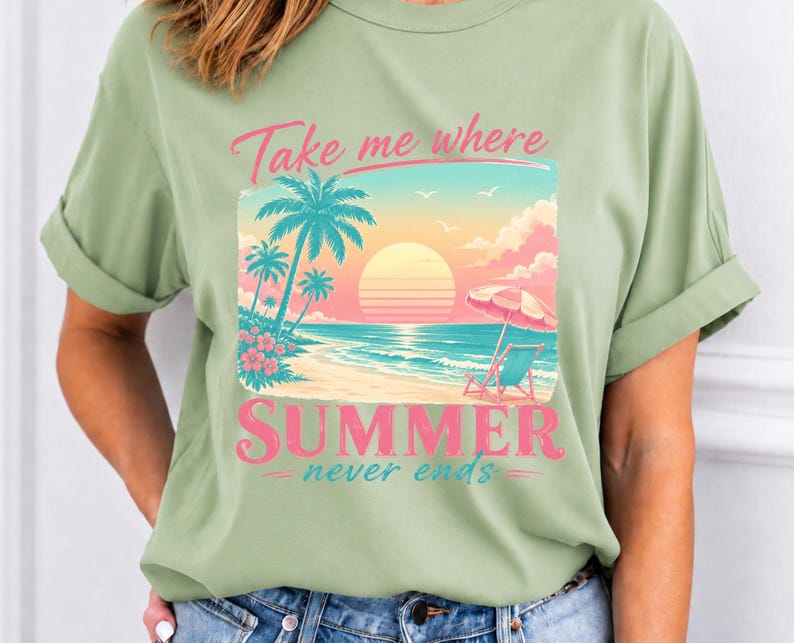 May include: A sage green t-shirt featuring a graphic print of a beach scene at sunset with palm trees, a beach chair, and an umbrella. The text reads "Take me where SUMMER never ends" in pink and teal lettering across the center of the shirt.