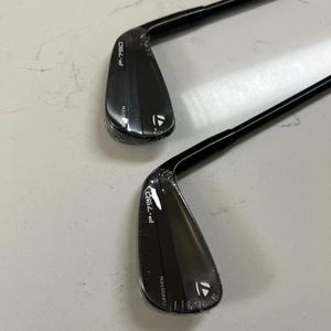 Puede incluir: Dos hierros de golf TaylorMade P-790 negros con varillas negras. Cada cabeza de palo presenta el texto P-790 y TUNGSTEN impreso en blanco, junto con el logotipo de TaylorMade. Las cabezas de los palos est&aacute;n envueltas en film pl&aacute;stico transparente.