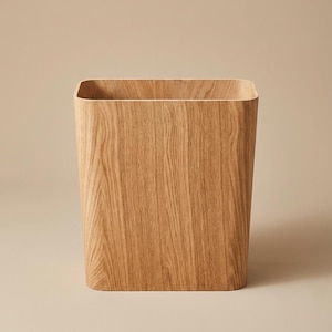 Peut inclure: Une corbeille à papier rectangulaire aux coins arrondis, fabriquée en bois clair avec un motif de grain vertical prononcé. Le récipient possède une ouverture sur le dessus et une finition lisse et uniforme, révélant la texture naturelle du bois.
