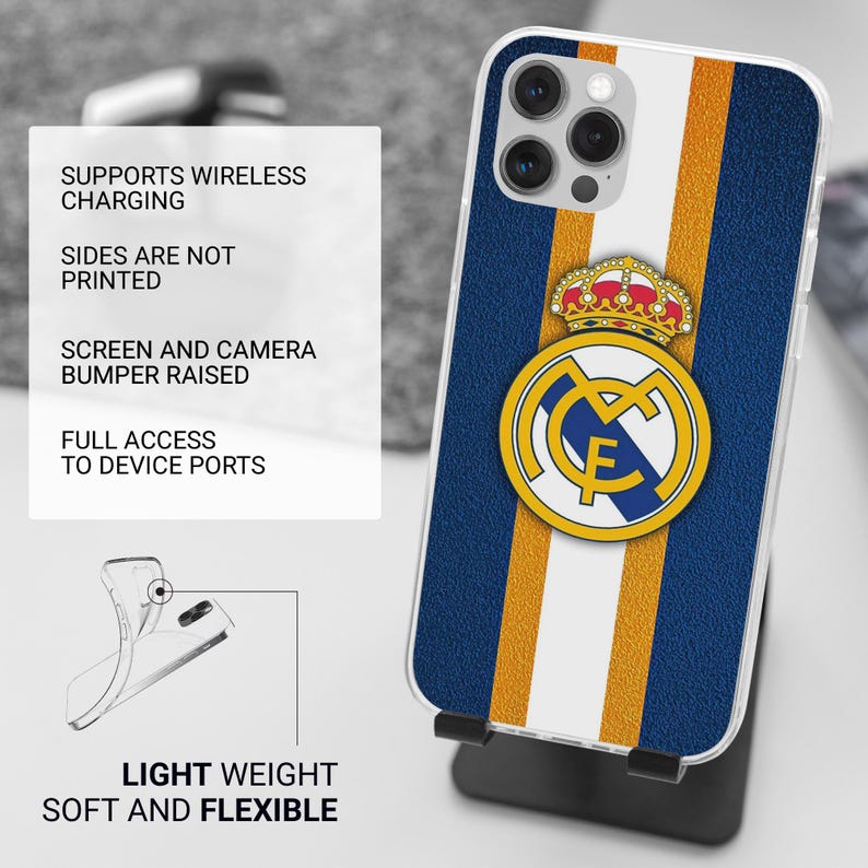 May include: A phone case featuring the Real Madrid logo centered over vertical blue, white, and gold stripes. The case has a raised camera bumper and supports wireless charging. Text on the image lists features including full access to device ports, light weight, soft and flexible construction, and unprinted sides.