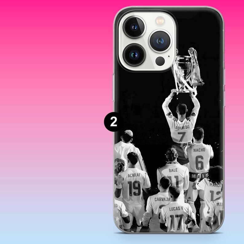 May include: A black and white phone case featuring a group of soccer players in white jerseys lifting a trophy. The players have names and numbers on their backs, including Ronaldo 7, Nacho 6, Bale 11, Achraf 19, Carvajal 2, and Lucas V 17.