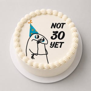 May include: A round white cake with a smooth frosting finish and a decorative piped border. The top features a black line drawing of a cartoon character wearing a blue party hat with orange stars, alongside the black text NOT 30 YET.