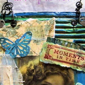 Pode incluir: Obra de arte em t&eacute;cnica mista com uma borboleta azul-turquesa, papel vintage e as palavras &laquo;Moments in Time&raquo;. A obra apresenta uma colagem de texturas, incluindo cart&atilde;o canelado e detalhes met&aacute;licos, com uma paleta de cores azul-turquesa, verde e s&eacute;pia.