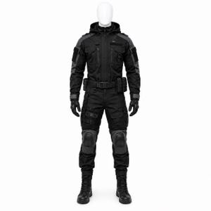 Könnte beinhalten: Ein schwarzer taktischer Overall mit Kapuzenjacke, mehreren Brusttaschen, einem Gürtel mit aufgesetzten Taschen, verstärkten Kniepolstern und langen Ärmeln mit dunkelgrauen Akzenten. Das Kleidungsstück wird mit schwarzen Handschuhen und Stiefeln getragen.