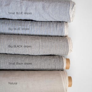 May include: Five rolls of fabric in different colors and patterns. The top roll is light blue with small blue stripes, the second roll is light blue with big blue stripes, the third roll is gray with big black stripes, the fourth roll is gray with small black stripes, and the bottom roll is a natural white color.