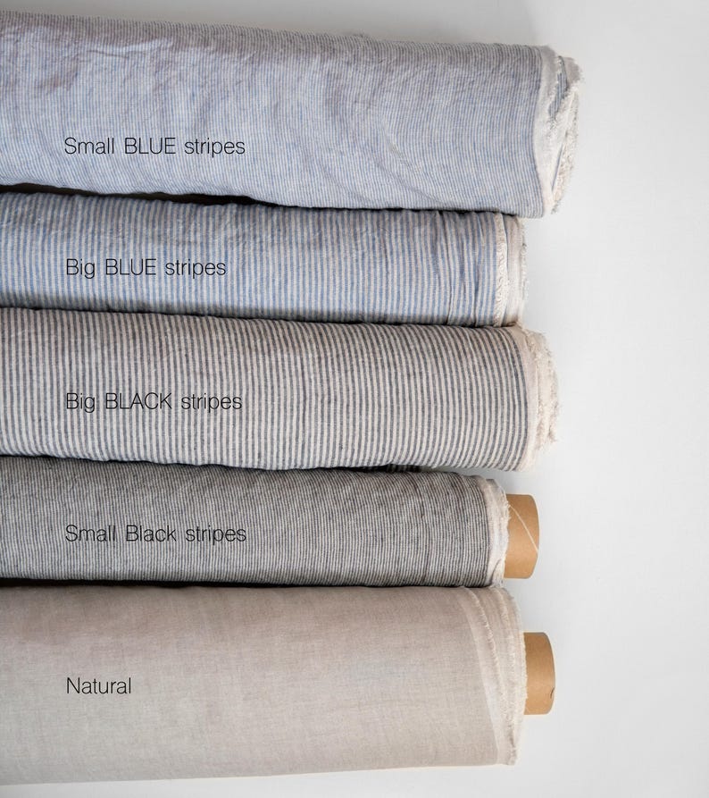 May include: Five rolls of fabric in different colors and patterns. The top roll is light blue with small blue stripes, the second roll is light blue with big blue stripes, the third roll is gray with big black stripes, the fourth roll is gray with small black stripes, and the bottom roll is a natural white color.