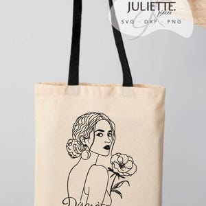 Könnte beinhalten: Eine beige Stofftasche mit schwarzen Henkeln, die eine schwarze Strichzeichnung einer Person mit einer Blume und das Wort "Discrète" am unteren Rand zeigt. In der oberen rechten Ecke steht der Text "JULIETTE. pieces SVG DXF PNG".