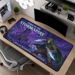 May include: A rectangular desk mat featuring a fantasy illustration with a dark purple sky, a stone tower, and a skeletal warrior in a green cloak holding glowing blue daggers. The text reads Curse of the Storm Spire and Rogue Warrior - Ascension.