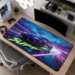 May include: A rectangular desk mat featuring a purple sports car speeding through a neon-lit night scene with motion blur effects. The word SUPRA is printed in large, bright green stylized letters across the lower portion of the mat surface.