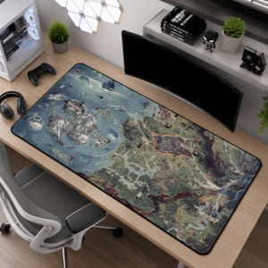 May include: A rectangular desk mat featuring a detailed fantasy map illustration with varied terrain including mountains, forests, and coastal waters. The map displays labeled regions and geographical landmarks in muted earth tones, blues, and greens.