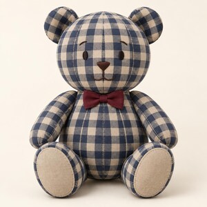 Puede incluir: Un oso de peluche con un patr&oacute;n de cuadros vichy en azul marino y beige en el cuerpo, la cabeza y las extremidades. El oso tiene ojos bordados en marr&oacute;n oscuro, una nariz marr&oacute;n, una boca cosida y una pajarita roja oscura lisa en el cuello.