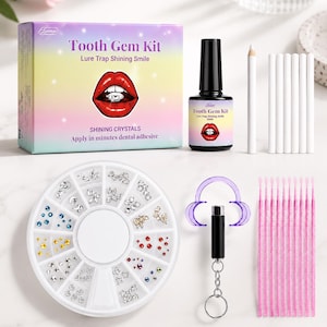 Könnte beinhalten: Ein Zahnschmuck-Set mit einer farbigen Box mit der Aufschrift Tooth Gem Kit Lure Trap Shining Smile, einer schwarzen Flasche mit Zahnkleber, einem weißen Wachsstift, sechs weißen Applikatoren, einer runden Dose mit Kristallen, einem lila Mundöffner und zehn rosa Pinseln.