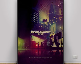 May include: A framed movie poster for Blade Runner 2049 featuring a dark, rain-swept cityscape in shades of purple, yellow, and green. The title Blade Runner 2049 is centred in gold text above two small silhouettes standing in a neon-lit street.