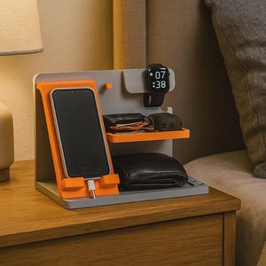 May include: A gray and orange multi-device charging station featuring a vertical stand for a smartphone, a dedicated hook for a smartwatch, and two horizontal shelves for storing small personal items like a wallet and earbuds case.