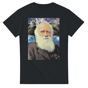 Op de afbeelding: Een zwart t-shirt met een grafische print van Charles Darwin met een lange witte baard, geflankeerd door twee gorilla's. Het ontwerp bevat abstracte blauwe en paarse patronen op de achtergrond, met twee extra blauwe ogen onder de gorilla's.