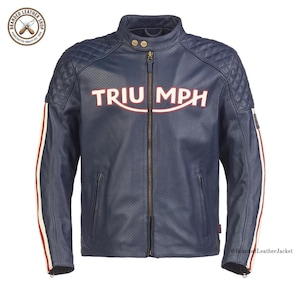 May include: A navy blue perforated leather jacket featuring a mandarin collar with two snap buttons, a central zipper, and the word TRIUMPH in white and red lettering across the chest. The shoulders have quilted panels and white and red stripes.