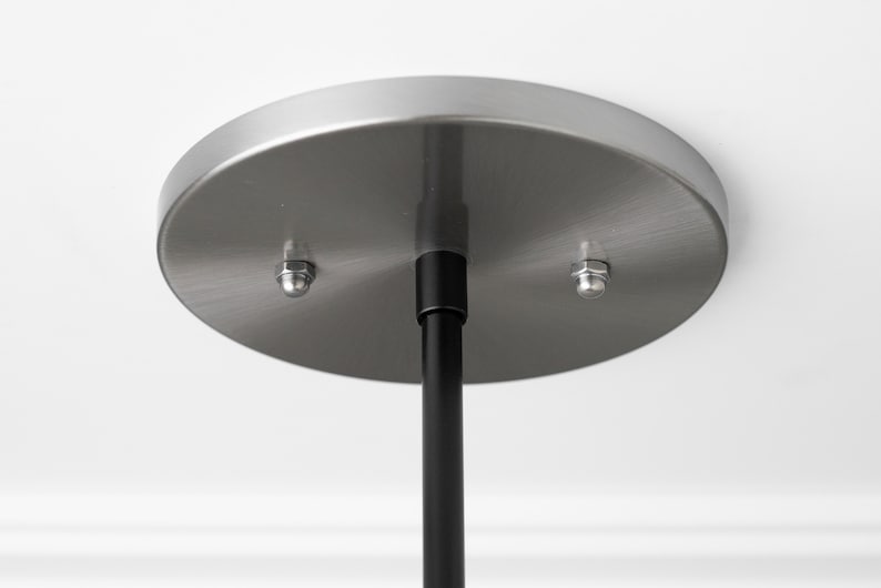 May include: A brushed nickel ceiling plate with two mounting screws and a black hanging rod.