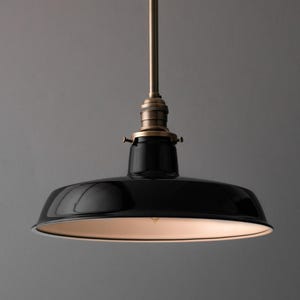 May include: Black pendant light with a white interior and a brass fixture.
