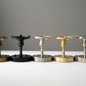 May include: Five ceiling light fixture base plates in different finishes: brass, black, nickel, gold, and silver.