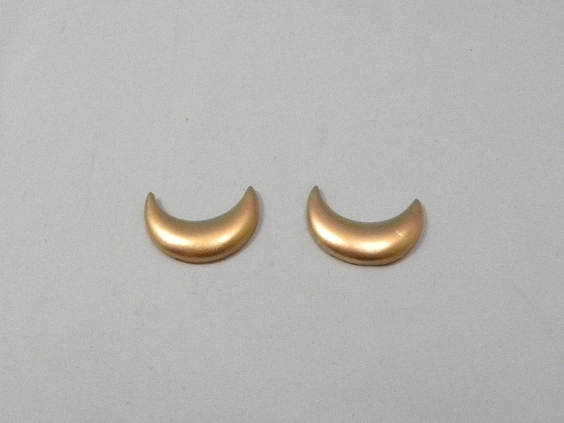 May include: A pair of gold crescent moon shaped earrings.