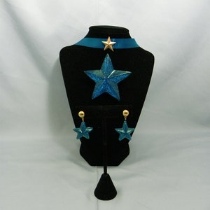 May include: A blue star-shaped necklace with a gold star charm and matching blue star earrings with gold accents.