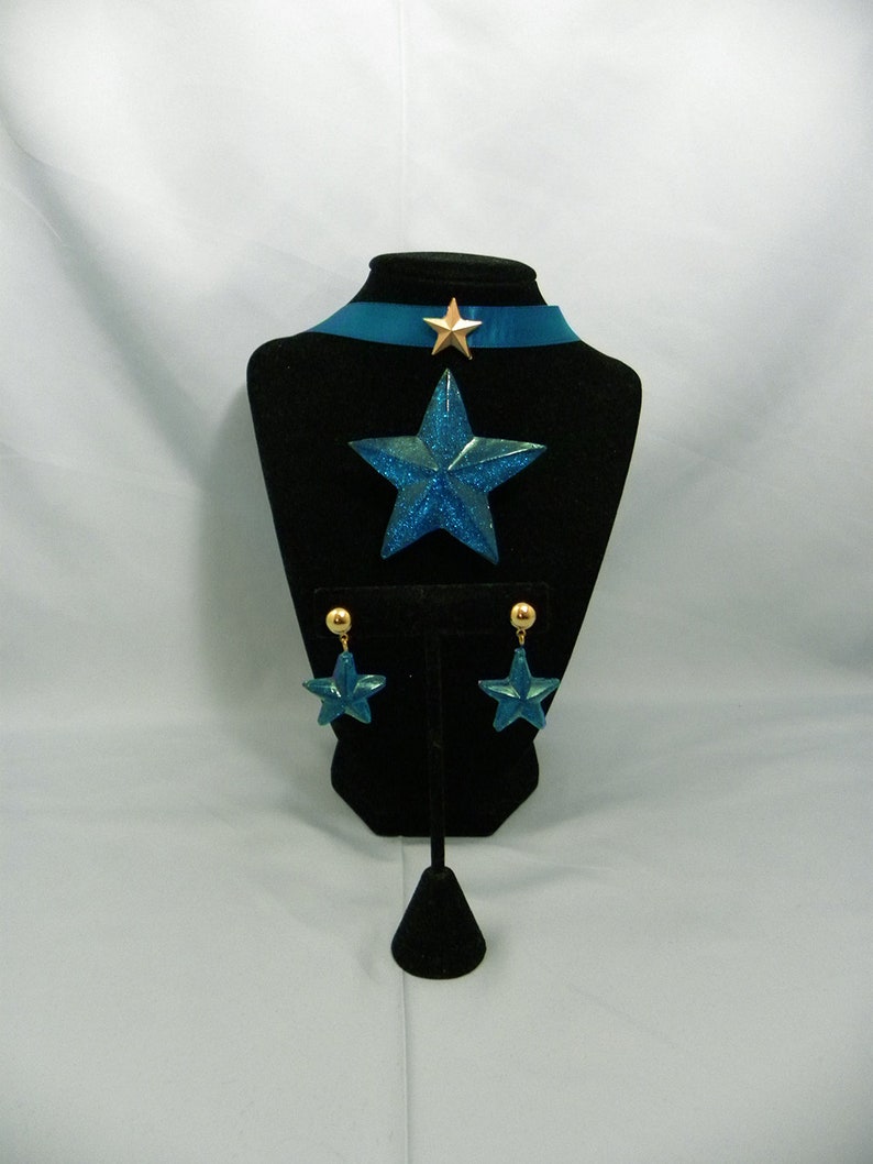 May include: A blue star-shaped necklace with a gold star charm and matching blue star earrings with gold accents.