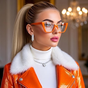 May include: Bright orange cat-eye glasses with clear lenses, worn with a white turtleneck sweater, a white faux fur collar, and a shiny orange jacket. The look is completed by a silver-toned crystal necklace and matching dangling crystal earrings.