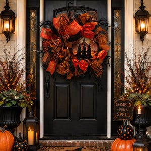 May include: A Halloween wreath featuring orange and black mesh, ribbons, and fabric roses, centered on a black door. Below, a brown doormat displays the text "Welcome" with a witch hat icon, flanked by pumpkins, lanterns, and a sign reading "COME IN FOR A SPELL."